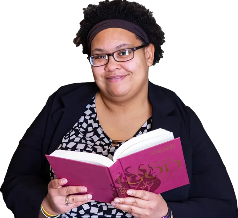 A woman holding a book and smiling