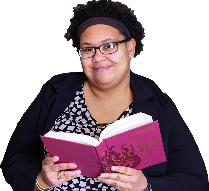 A woman holding a book and smiling